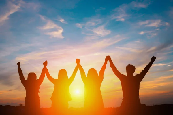 Silhouet van gelukkig business team maken hoge handen in stad terug — Stockfoto