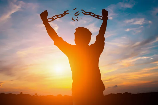 Silhouette image of a businessman with broken chains in sunset — Stock Photo, Image