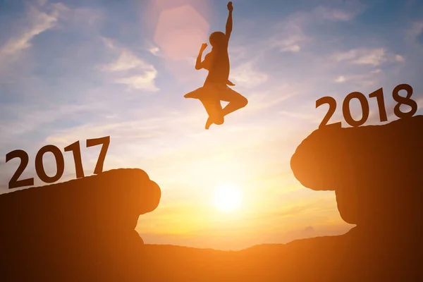 Silueta šťastný muž skok mezi roky 2017 a 2018 v sluncí — Stock fotografie
