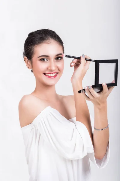 Vacker kvinna är nöjd med makeup på vit bakgrund — Stockfoto