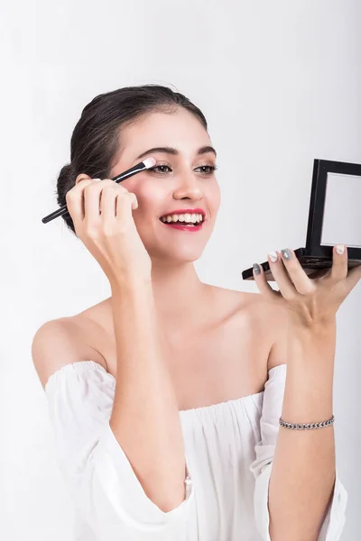 Hermosa mujer es feliz con el maquillaje En un fondo blanco —  Fotos de Stock