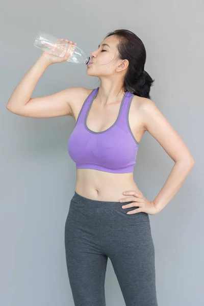 Mujer joven está bebiendo agua después del ejercicio . —  Fotos de Stock