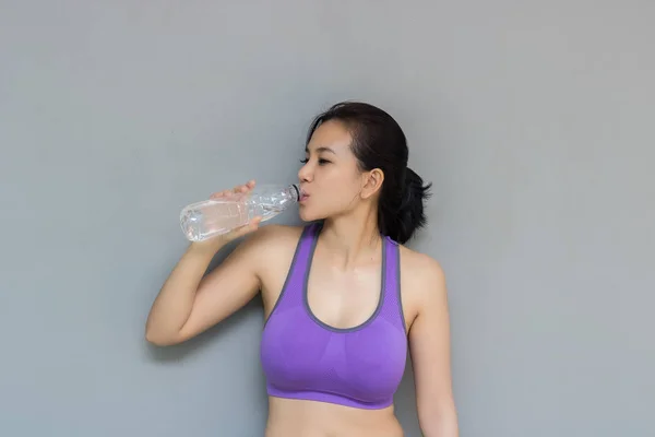 Mujer joven está bebiendo agua después del ejercicio . — Foto de Stock