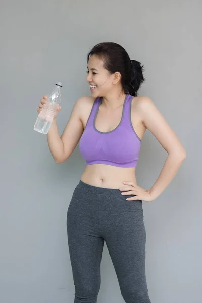 Mujer joven está bebiendo agua después del ejercicio . —  Fotos de Stock