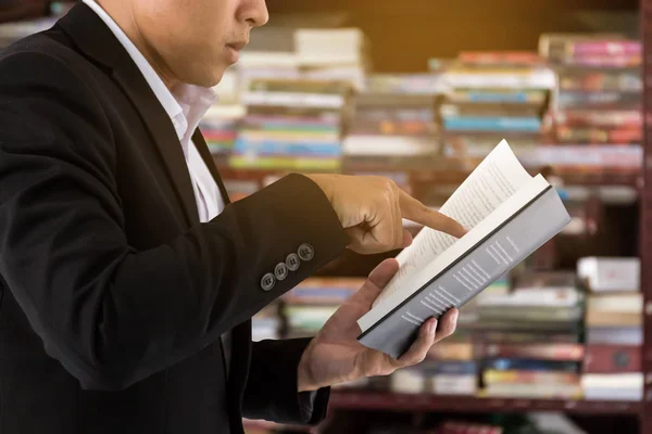 Kitaplığındaki kitap okuyarak işadamı