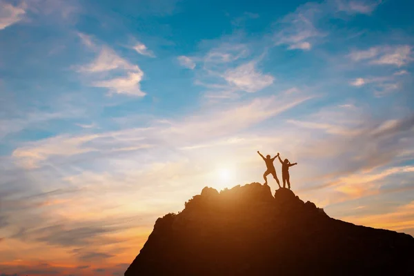 Silhueta de pessoas felizes no pôr do sol no penhasco — Fotografia de Stock