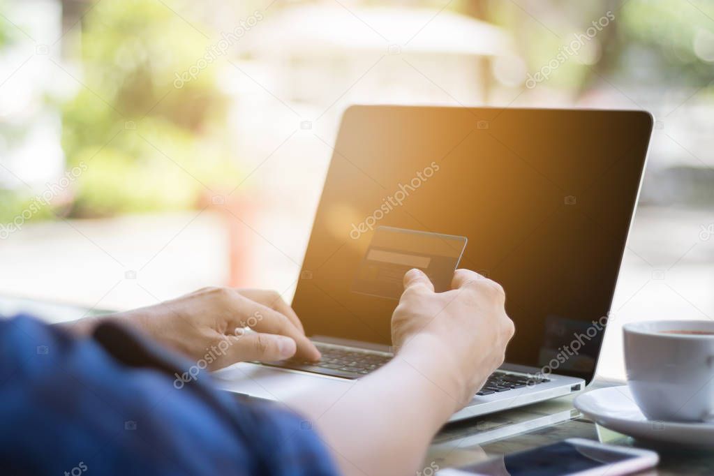 Hand holding credit card for online shopping on laptop ecommerce