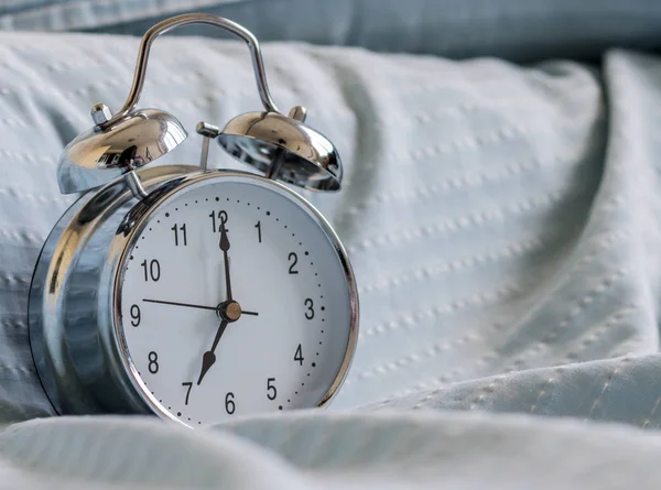 Clock on the bed in the morning. Stock Image