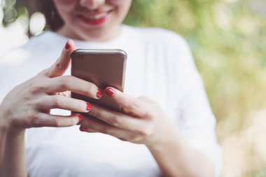 Bir kadın parkta smartphone kullanıyorsanız.