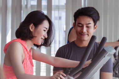 Çiftler spor salonunda egzersiz yapıyor..