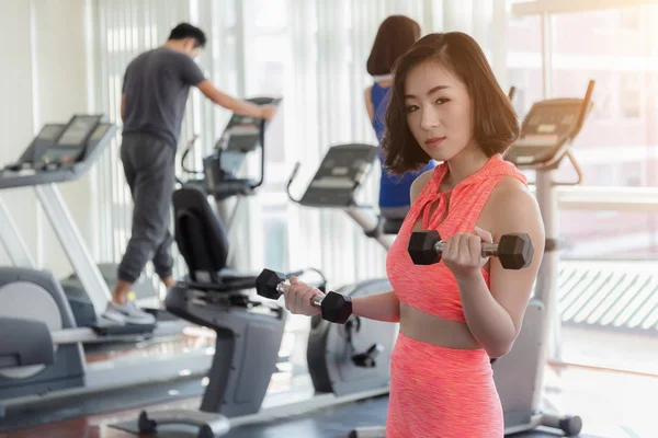 Close up of happy Asian woman exercising in the gym for good hea