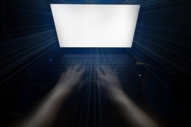 Karanlık bir odada bir dizüstü bilgisayar klavye yazarak eller.