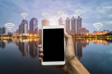 Bir smartphone tutan el. Wi-Fi bağlantısı şehirde