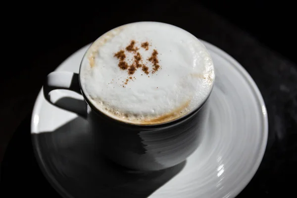 Güneş ışığı bol olan masada sıcak cappuccino. — Stok fotoğraf