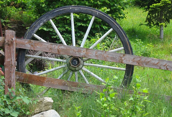 Roda de papelão antiga perto de uma cerca de madeira — Fotografia de Stock
