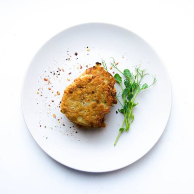 Beyaz tabakta bezelye filizli patatesli gözleme. 