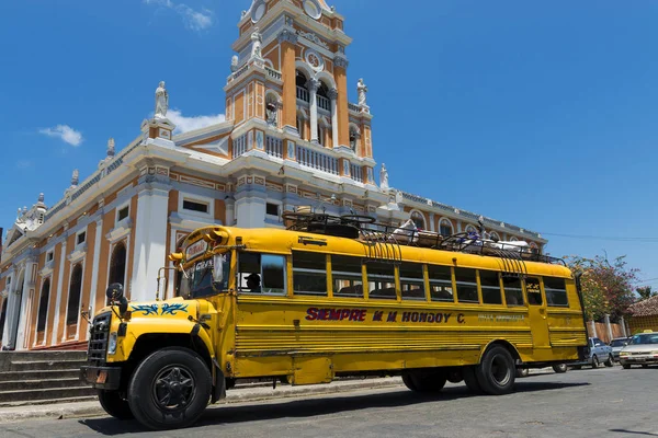 Autobús frente a una iglesia en una calle de la ciudad colonial de Granada, en Nicaragua — Foto de Stock