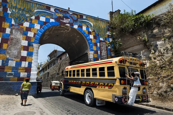 Autobús con un hombre sosteniendo un bar en la parte trasera entrando en la ciudad de Chichicastenango, en Guatemala — Foto de Stock