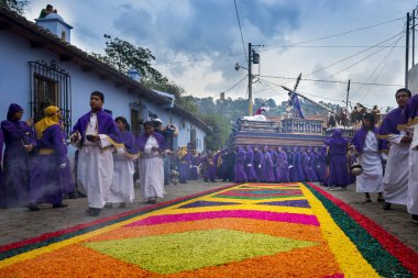 Mor ve beyaz elbiseler giyen adam Antigua, Guatemala kutsal hafta Paskalya kutlamaları sırasında bir float (anda) taşıma.