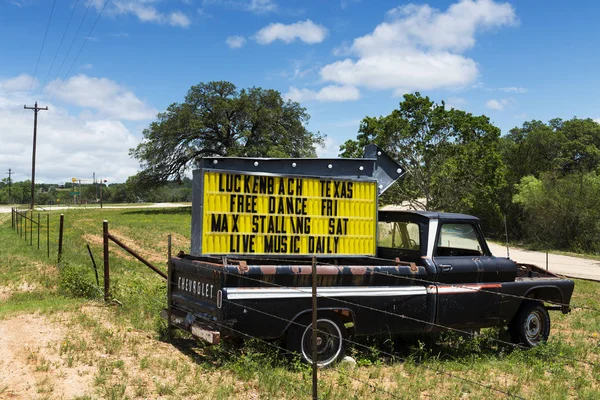 Alter truck mit einem schild für ein musik-event in luckenbach, texas, usa. — Stockfoto