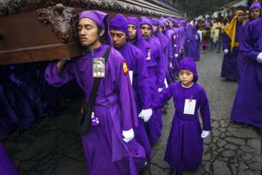 Mor elbiseler giyen adam Antigua, Guatemala kutsal hafta Paskalya kutlamaları sırasında bir float (anda) taşıma.
