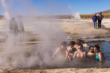 İnsanlar o Geysers del Tatio alan Atacama Çölü, kuzey Şili'de kaplıca havuzu içinde banyo