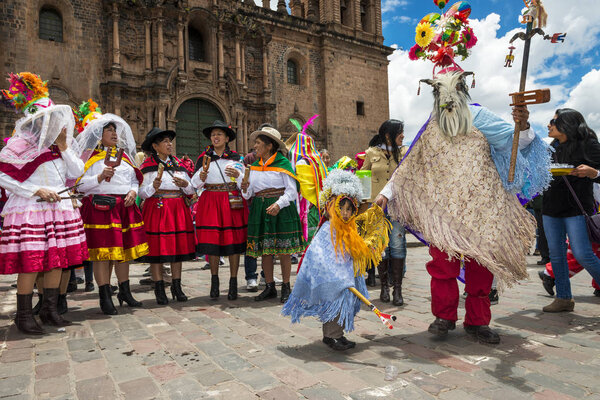 People wearing traditional clothes and masks dancing the Huaylia in the Christmas day in front of the Cuzco Cathedral in Cuzco, Peru.