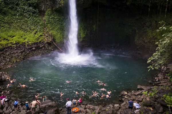 Le persone che nuotano nella piscina della cascata La Fortuna in Costa Rica . — Foto Stock