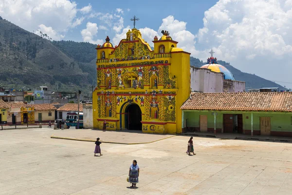 La colorata chiesa di San Andres Xecul e tre donne Maya locali che camminano per strada in Guatemala — Foto Stock