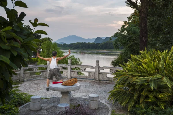 Homem praticando Tai chi nas margens do rio Li em Guilin, China . — Fotografia de Stock