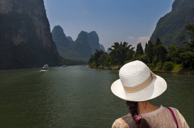 Kadın bakarak bir şapka ile bir nehir manzarası arasında Guilin ve Yangshuo, Çin'Li nehre cruise