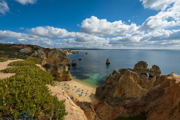 Ludzie na pięknej plaży Camilo (Praia do Camil) i okoliczne klify w Lagos, Portugalia — Zdjęcie stockowe