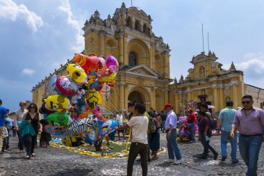 Guatemala arka planda bir sokakta Antigua eski şehir San Pedro hastane ile balon satan genç çocuk