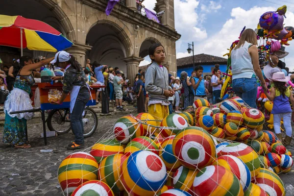 Young girl selling colorful rubber balls in a street of the old city of Antigua, in Guatemala — Stock Photo, Image