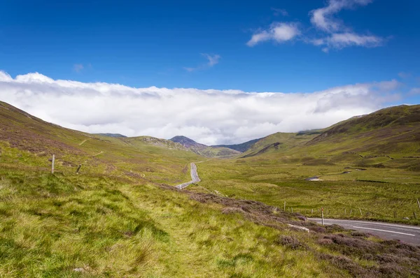 Carretera estrecha a lo largo de un valle en las Highlands escocesas en Escocia, Reino Unido — Foto de Stock