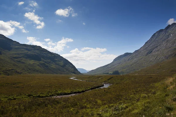 Река Мбаппе, протекающая по валу, окруженному горами в Шотландии, Великобритания — стоковое фото