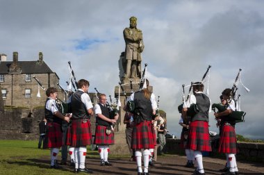 Robert heykeli önünde oynayan Bruce Stirling, İskoçya, Birleşik Krallık'taki Stirling kalesinde pipers grup