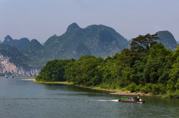 Kleine boot in de Li rivier waar de hoge kalkstenen pieken op de achtergrond in de buurt van Yangshuo in China — Stockfoto