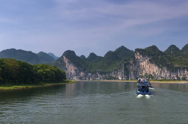 Barcos de pasajeros con turistas en el río Li con los altos picos de piedra caliza en el fondo cerca de Yangshuo en China — Foto de Stock