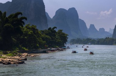 Yangshuo, Çin - 1 Ağustos 2010: Tekne turist Yangshuo Çin, Asya yakın planda uzun boylu kireçtaşı zirveleri ile Li Nehri seyir.