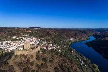 Belver Castle (Castelo de Belver) ve Portekiz'de arka planda Tagus Nehri üzerinde köprü ile köy hava görünümünü; Kavram Portekiz seyahat ve Portekiz en güzel yerleri