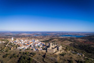 Aerial view of the historic village of Monsaraz in Alentejo with the Alqueva dam reservoir on the background; Concept for travel in Portugal and Alentejo and most beautiful places in Portugal clipart