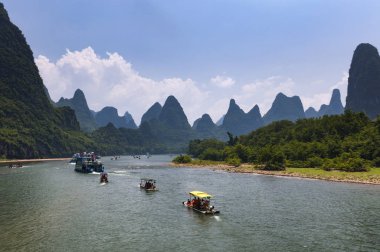 Yangshuo, Çin - 1 Ağustos 2012: Tekne turist Yangshuo Çin, Asya yakın planda uzun boylu kireçtaşı zirveleri ile Li Nehri seyir.