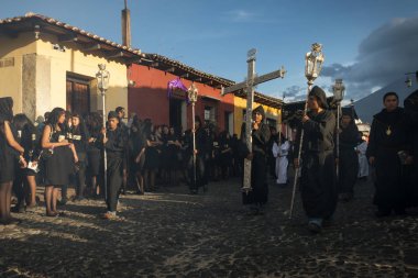 Antigua, Guatemala - 19 Nisan 2014: siyah elbiseler ve davlumbaz Antigua eski şehir bir sokakta bir alay Antigua, Guatemala kutsal hafta sırasında giyen adam