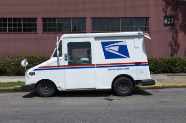 New Orleans, Louisiana - June 17, 2014: United States Postal Service (USPS) truck parked in a street of the city of New Orleans in Louisiana, USA. clipart