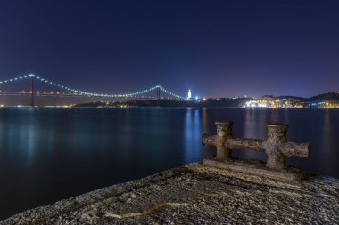 Bankaların Tagus Nehri (Rio Tejo) Nisan köprü 25 ile gece artalan üzerinde eski bir iskele ayrıntısı; Ziyaret Lizbon için kavram ve çoğu beaufiful yerde Portekiz
