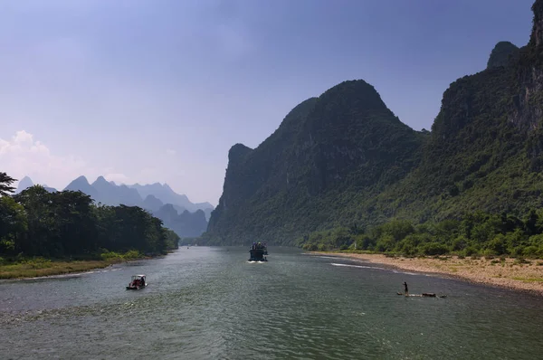 Yangshuo, China - August 1, 2010: Rafts and boats with tourists cruising in the Li River near the town of Yangshuo in China, Asia.