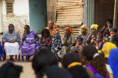 Bissau, Republic of Guinea-Bissau - January 29, 2018: Portrait of a group of women and children at a community reunion in the Bissaque neighborhood in the city of Bissau, Guinea Bissau. clipart