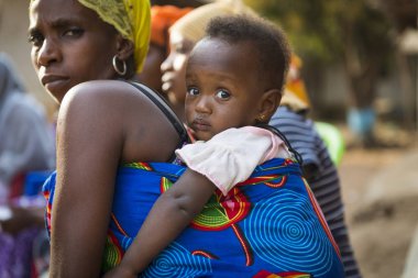 Bissau, Gine Cumhuriyeti - 29 Ocak 2018: şehir Bissau, Gine Bissau Bissaque mahallede, onun annesi omuzlarında taşınırken bir bebek kız portresi.