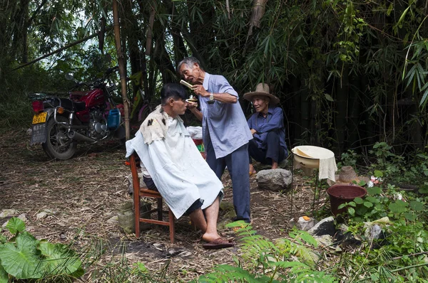 2012年8月2日 在中国阳朔郊区一个农村地区理发的男子 — 图库照片